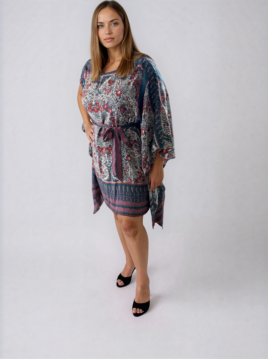 Front view of the ZALA rayon kaftan dress in the Heirloom Blue print, featuring a white base with intricate floral and ornamental motifs framed by rich blue borders and muted berry accents. Styled with the sash tied at the front to create a softly defined waist, with a relaxed boat neckline and flowing sleeve slits.