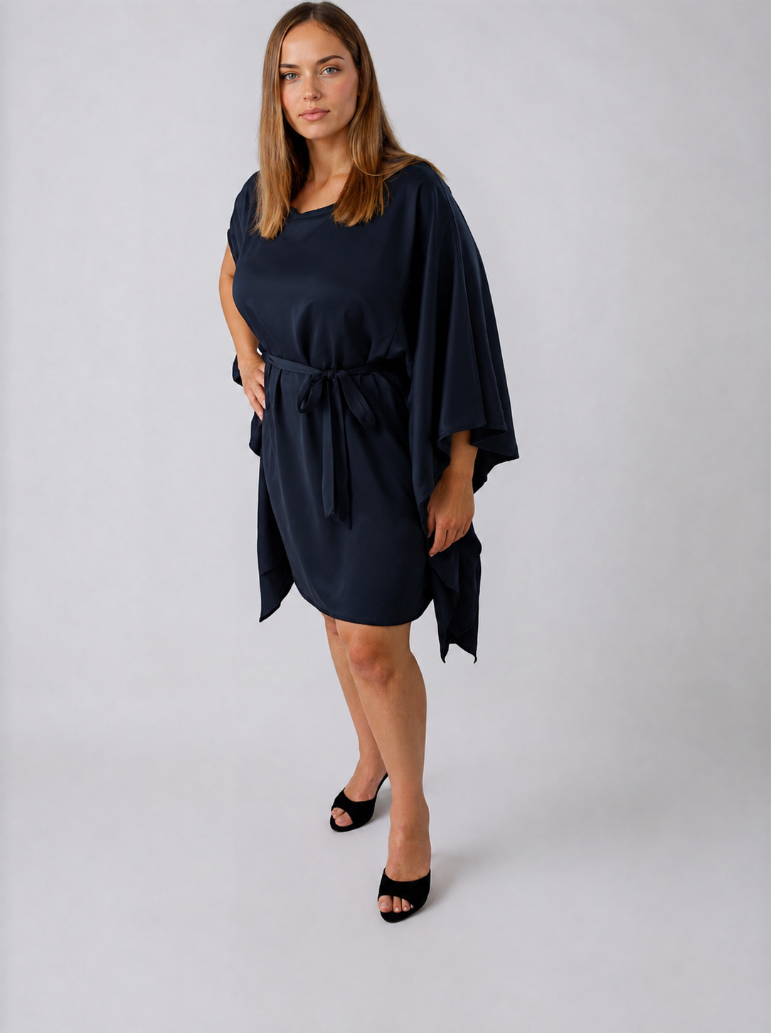 Front view of the ZALA silk kaftan dress in Navy, crafted from lustrous silk charmeuse with a fluid drape and elegant sheen. Styled with the sash tied at the front to softly define the waist, while the relaxed boat neckline and draped sleeve slits create an effortlessly sophisticated silhouette.